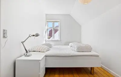 a white bedroom with a bed and a lamp at Nice Home In Løgstør With Wifi in Løgstør