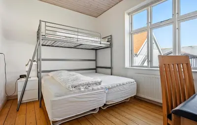 a bedroom with a bunk bed and two windows at Nice Home In Løgstør With Wifi in Løgstør