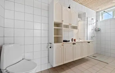 a white bathroom with a toilet and a sink at Nice Home In Løgstør With Wifi in Løgstør