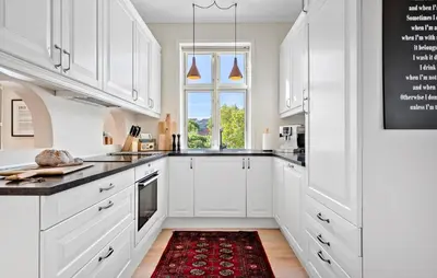 a kitchen with white cabinets and a red rug at Nice Home In Løgstør With Wifi in Løgstør