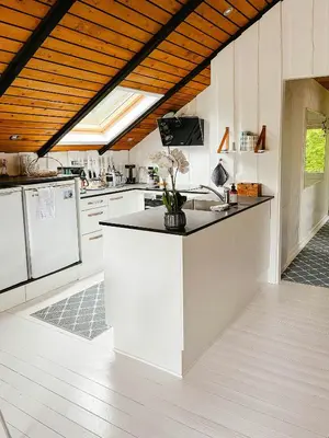 a kitchen with white counters and white appliances at Simple Cottage Close To Limfjorden in Åbybro