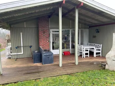 a wooden deck with awning on a house at Hygge in the North Sea Cabin in Fjerritslev