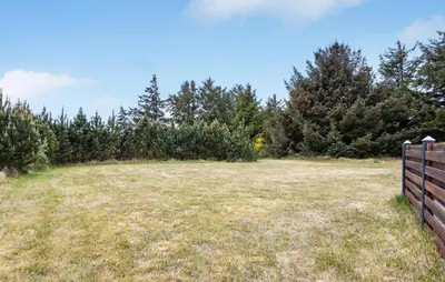 a field with a fence and trees in the background at 3 Bedroom Beautiful Home In Thisted in Thisted
