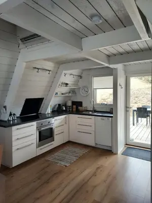 a kitchen with white cabinets and a large window at Holiday home golf house in beautiful Himmerland Farsø in Farsø