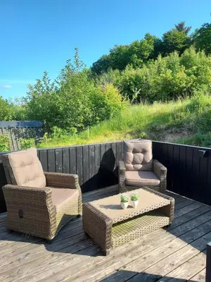 two chairs and a coffee table on a deck at Holiday home golf house in beautiful Himmerland Farsø in Farsø