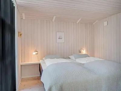 a bedroom with a bed and a table and lights at Holiday Home Atti - 500m to the fjord by Interhome in Højslev
