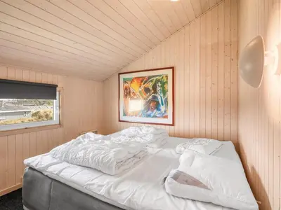 a white bed in a room with a picture on the wall at Holiday Home Elni - 350m from the sea by Interhome in Blokhus