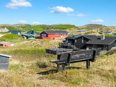 a bench sitting on top of a hill with houses at Holiday Home Elni - 350m from the sea by Interhome in Blokhus
