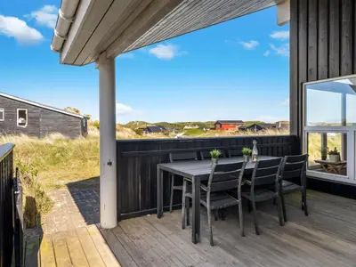 a patio with a table and chairs on a deck at Holiday Home Elni - 350m from the sea by Interhome in Blokhus