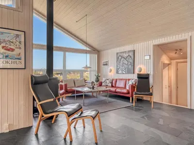 a living room with a red couch and a table at Holiday Home Elni - 350m from the sea by Interhome in Blokhus