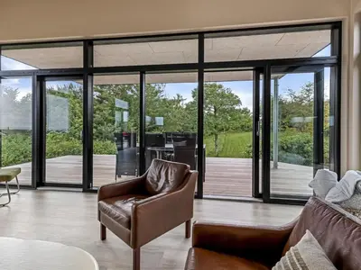 a living room with a couch and a chair at Holiday Home Stjerne - 300m to the fjord by Interhome in Lemvig