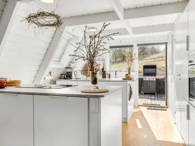 a kitchen with white cabinets and a large window at Apartment Kauno - 16km to the fjord by Interhome in Farsø
