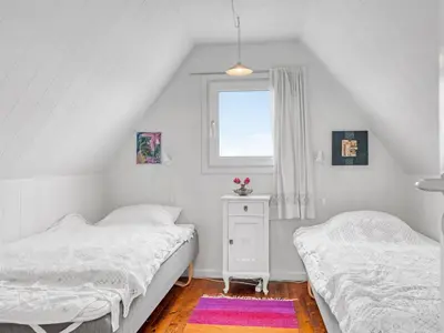 two beds in a white room with a window at Holiday Home Arkil - 200m from the sea by Interhome in Harboør