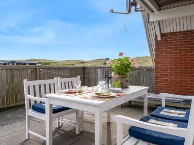a white table and chairs on a patio at Holiday Home Arkil - 200m from the sea by Interhome in Harboør