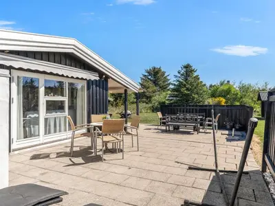 a patio with chairs and a table and a grill at Holiday Home Rieke - 2km from the sea by Interhome in Blokhus