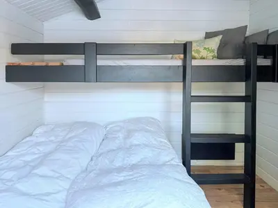 a bedroom with two bunk beds and a ladder at Traditional Summer House Near Blokhus Beach in Blokhus