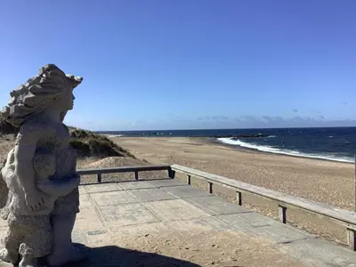 a statue of a woman standing next to the beach at 6 person holiday home in Vestervig in Vestervig