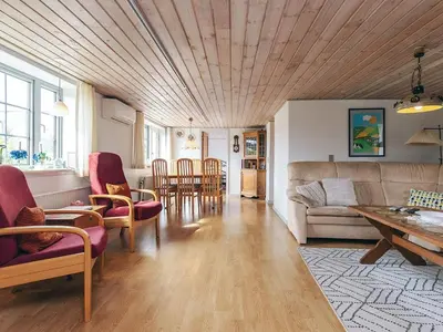 a living room with a couch and a table and chairs at 6 person holiday home in Vestervig in Vestervig