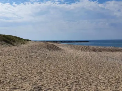 a sandy beach with the ocean in the background at 4 person holiday home in Vestervig in Vestervig