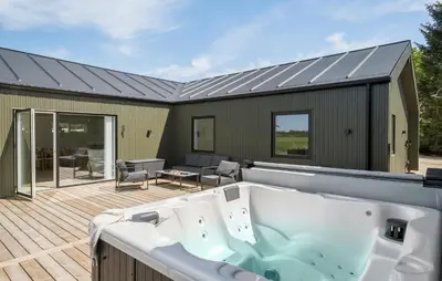 a bath tub on a deck with a house at Pet Friendly Home In Saltum With Sauna in Saltum