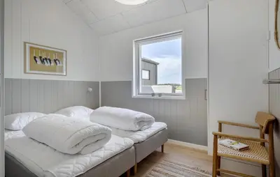 a bedroom with a bed with white pillows on it at Pet Friendly Home In Saltum With Sauna in Saltum