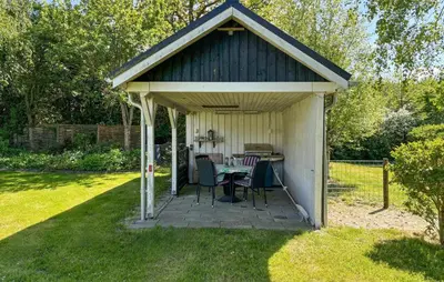a gazebo with a table and chairs in a yard at 2 Bedroom Cozy Home In Farsø in Farsø