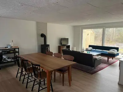 a living room with a table and a couch at Holiday Home In 1St Row By The Limfjord in Thyholm