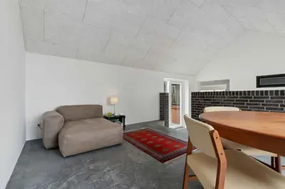 a living room with a table and a couch at Holiday Home In 1St Row By The Limfjord in Thyholm