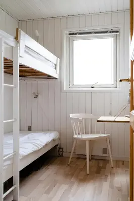 a bedroom with a bunk bed and a desk and a chair at Cosy, Traditional Summer House Close To The North Sea in Fjerritslev