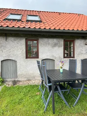 a black table and chairs in front of a house at Stalden ved Hjarbækgård in Løgstrup