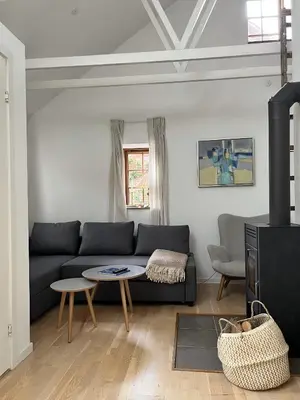 a living room with a couch and a table at Stalden ved Hjarbækgård in Løgstrup