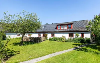 a white house with red windows and a yard at Lovely Home In Nibe With Lake View in Nibe