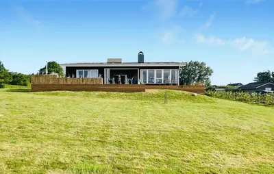 a house sitting on top of a grassy hill at 3 Bedroom Stunning Home In Øster Assels in Øster Assels
