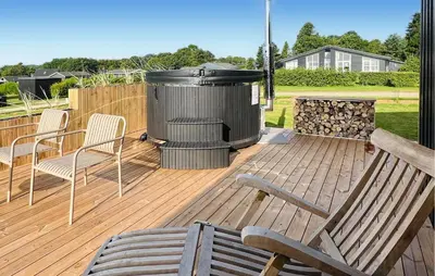 a deck with a trash can and chairs and a grill at 3 Bedroom Stunning Home In Øster Assels in Øster Assels