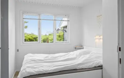 a bed in a white room with a window at Amazing Home In Løkken With Wifi in Løkken