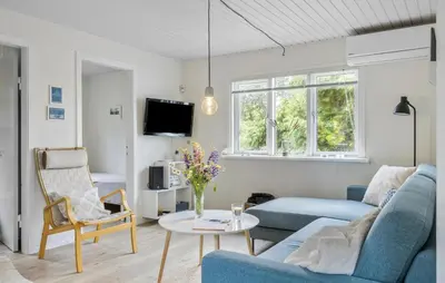 a living room with a blue couch and a table at Amazing Home In Løkken With Wifi in Løkken