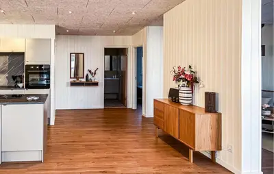 a kitchen and living room with a vase of flowers on a cabinet at Awesome Home In Vinderup With Sauna in Vinderup