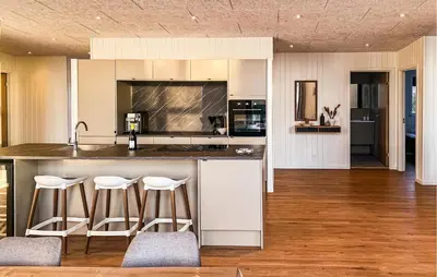 a kitchen with a counter and bar with stools at Awesome Home In Vinderup With Sauna in Vinderup