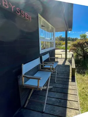 a group of benches sitting on the side of a house at Architect-Designed Holiday Home By Saltum Beach in Saltum