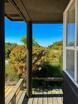 a view from the porch of a house with a window at Architect-Designed Holiday Home By Saltum Beach in Saltum
