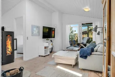 a living room with a fireplace and a couch at Well-Maintained Holiday Home With Outdoor Shower And 5-Person Outdoor Hot Tub, Close To The North Sea In Klitmøller in Klitmøller