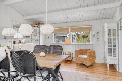a dining room with a table and chairs at Beautifully Renovated Holiday Home With Covered Terrace And Wood-Burning Stove, Close To The North Sea In Thy in Sønder Vorupør