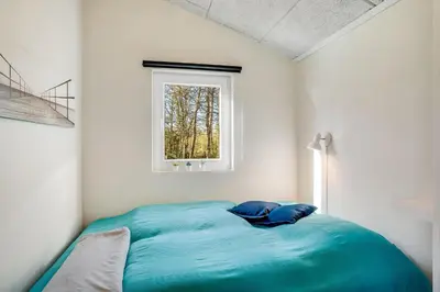 a bed in a white room with a window at Lovely Renovated Holiday Home With A Wilderness Bath And Fenced Grounds in Vesløs
