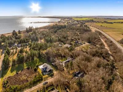 an aerial view of a house on the shore of a lake at Lovely Renovated Holiday Home With A Wilderness Bath And Fenced Grounds in Vesløs