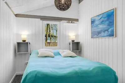 a bedroom with a large blue bed with two pillows at Lovely Renovated Holiday Home With A Wilderness Bath And Fenced Grounds in Vesløs