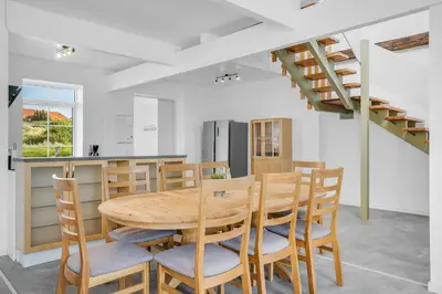 a kitchen and dining room with a wooden table and chairs at Renovated Holiday Home With Free Consumption, Close To The North Sea And The Center Of Hanstholm in Hanstholm