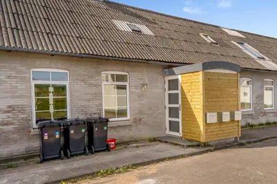 a building with a row of trash cans in front of it at Renovated Holiday Home With Free Consumption, Close To The North Sea And The Center Of Hanstholm in Hanstholm