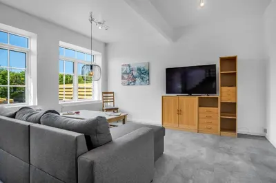 a living room with a couch and a flat screen tv at Renovated Holiday Home With Free Consumption, Close To The North Sea And The Center Of Hanstholm in Hanstholm