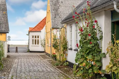 a cobblestone street in a town with houses at Charming Townhouse From 1877, Located In The Middle Of Løgstør Only 100 Meters From The Harbor in Løgstør