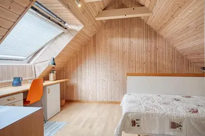a bedroom with a bed in a room with wooden walls at Charming Townhouse From 1877, Located In The Middle Of Løgstør Only 100 Meters From The Harbor in Løgstør